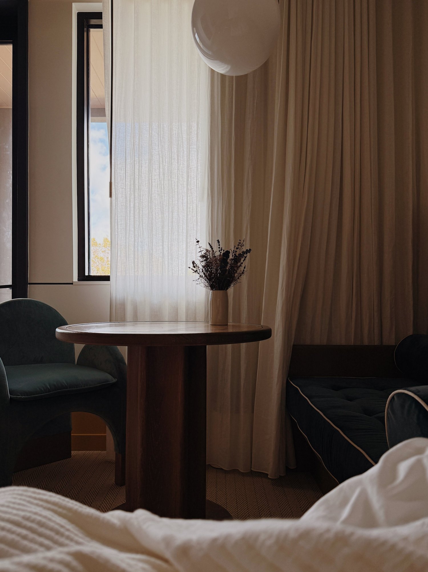 Hotel suite bedroom with soft window light